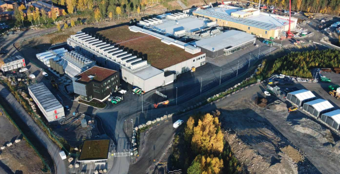 Luftfoto af EcoDataCenters campus med flere bygninger og træer om efteråret. Luftfoto af EcoDataCenters campus med flere bygninger og træer om efteråret.